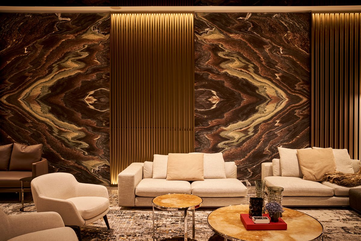 Bookmatched Blue Galaxy marble panels bring a dramatic touch to the gold-accented living room