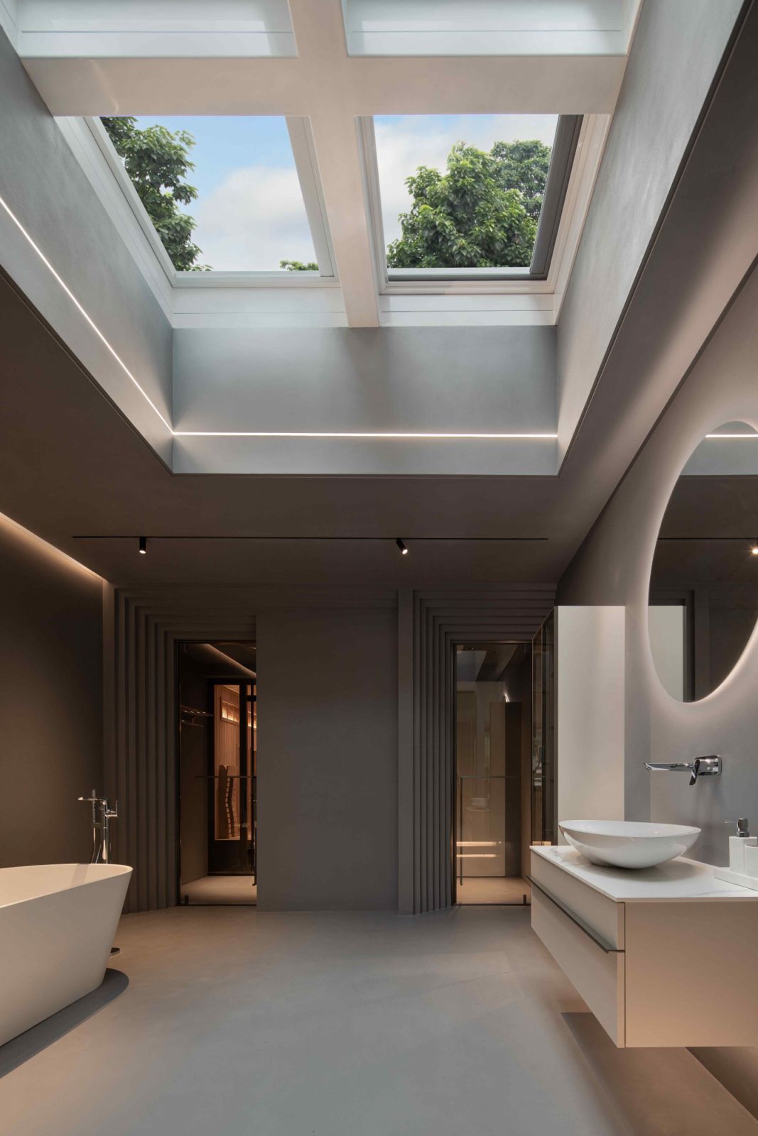 A minimal oval tub with an expansive skylight overhead