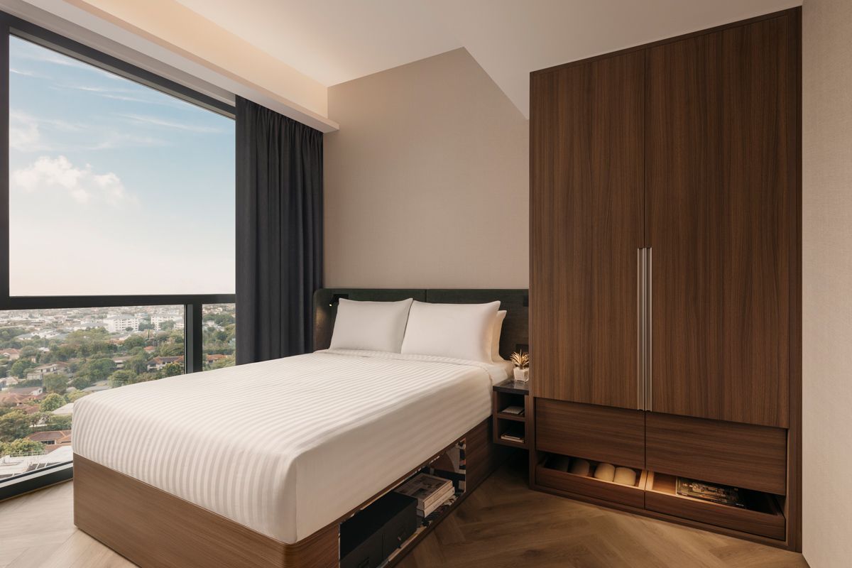 The One-Bedroom Deluxe's restful bedroom has a sweeping view of the neighbourhood