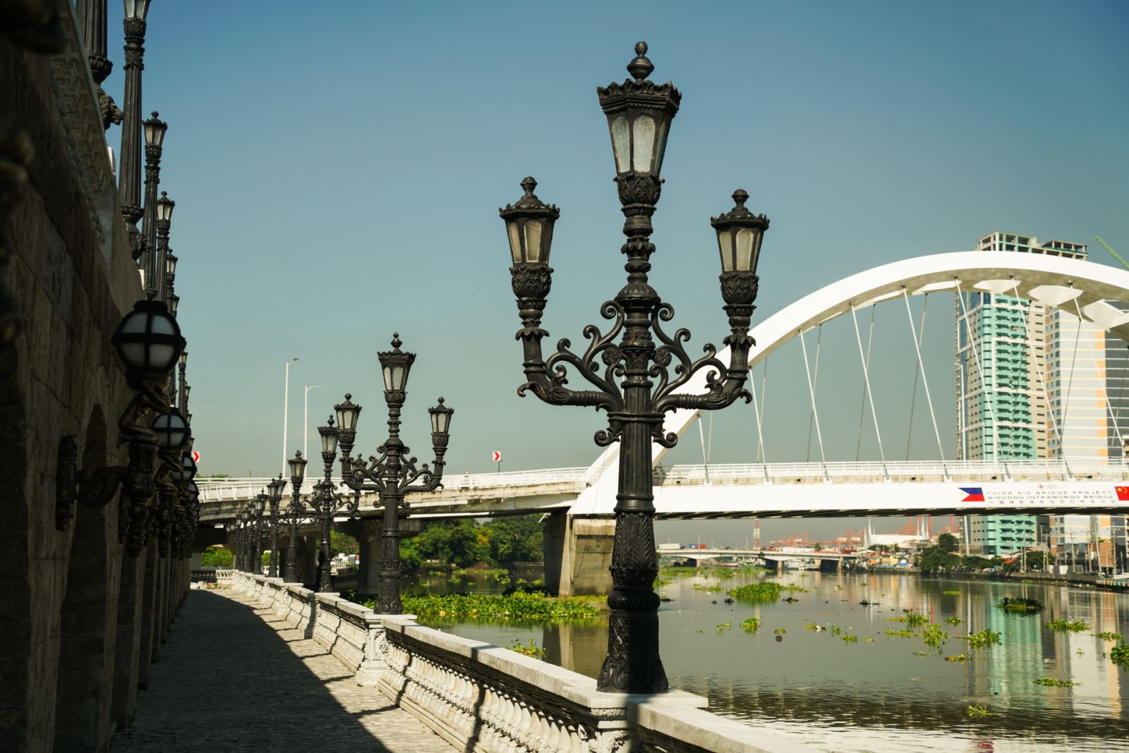 Intricately designed lamp posts line the pathway, overlooking the Binondo-Intramuros Bridge