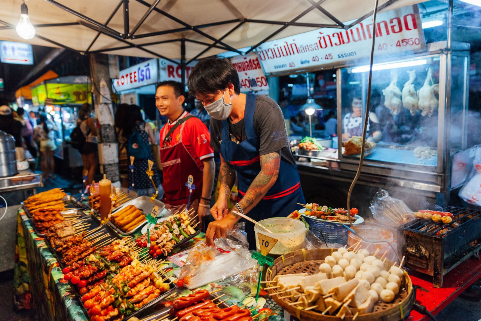 Chiang Mai, Thailand - August 27, 2016: Young man sells satay at the Saturday Night Market.