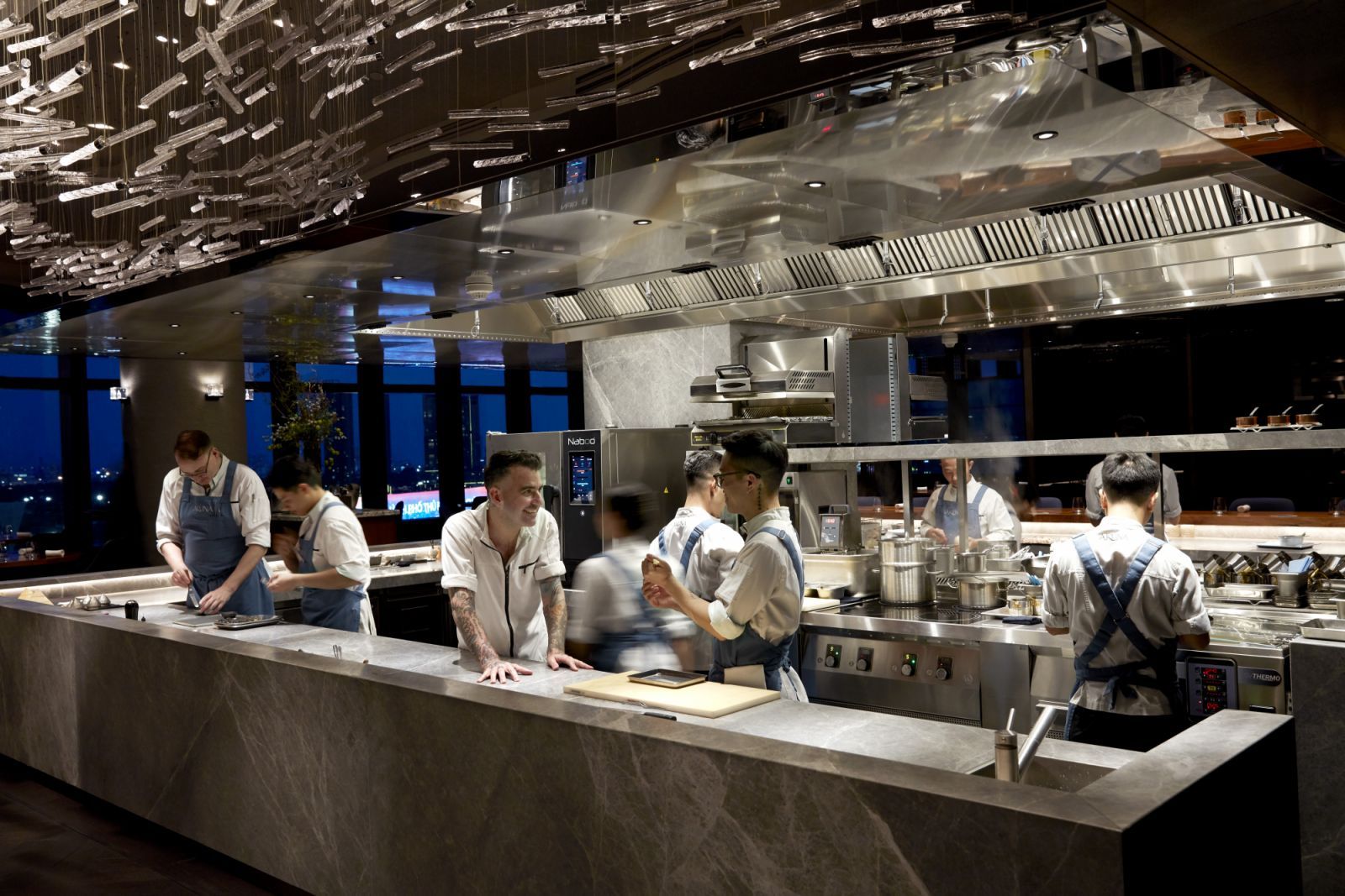 Chef Sam Aisbett with staff at the open kitchen counter