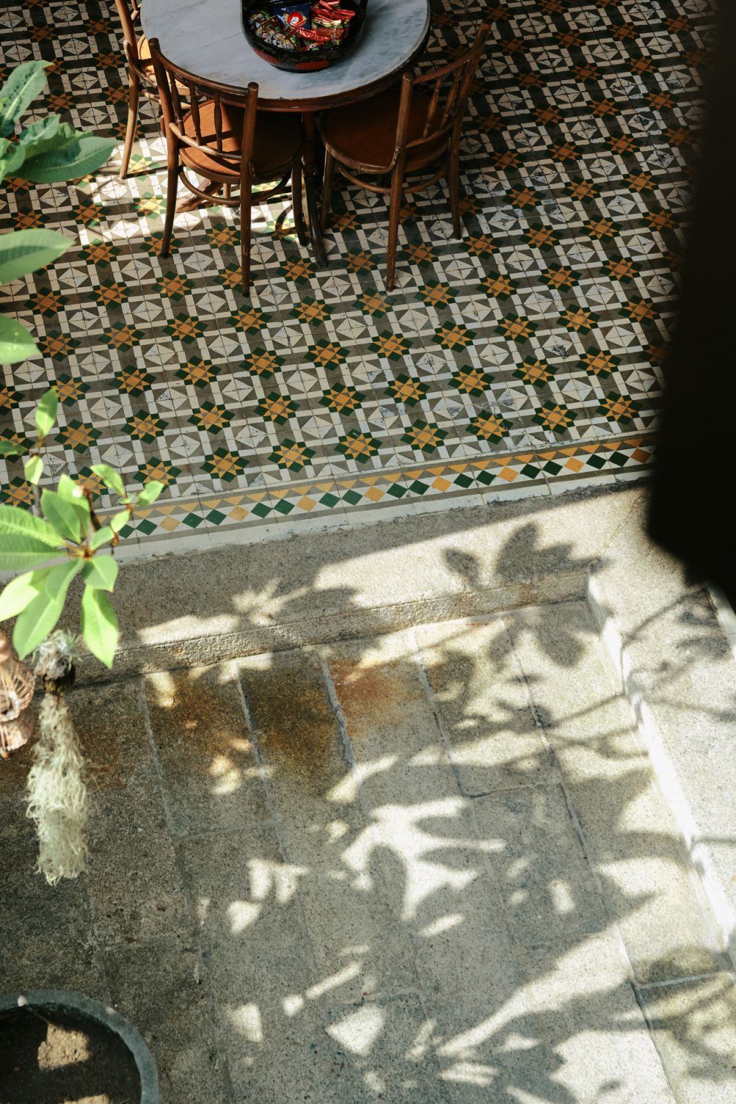 Original Peranakan floor tiles with intricate geometric patterns remain preserved in the hotel's common areas, showcasing the building's authentic 1920s craftsmanship