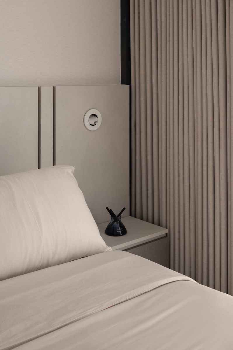 The bed headboard extends to the side to include bedside tables