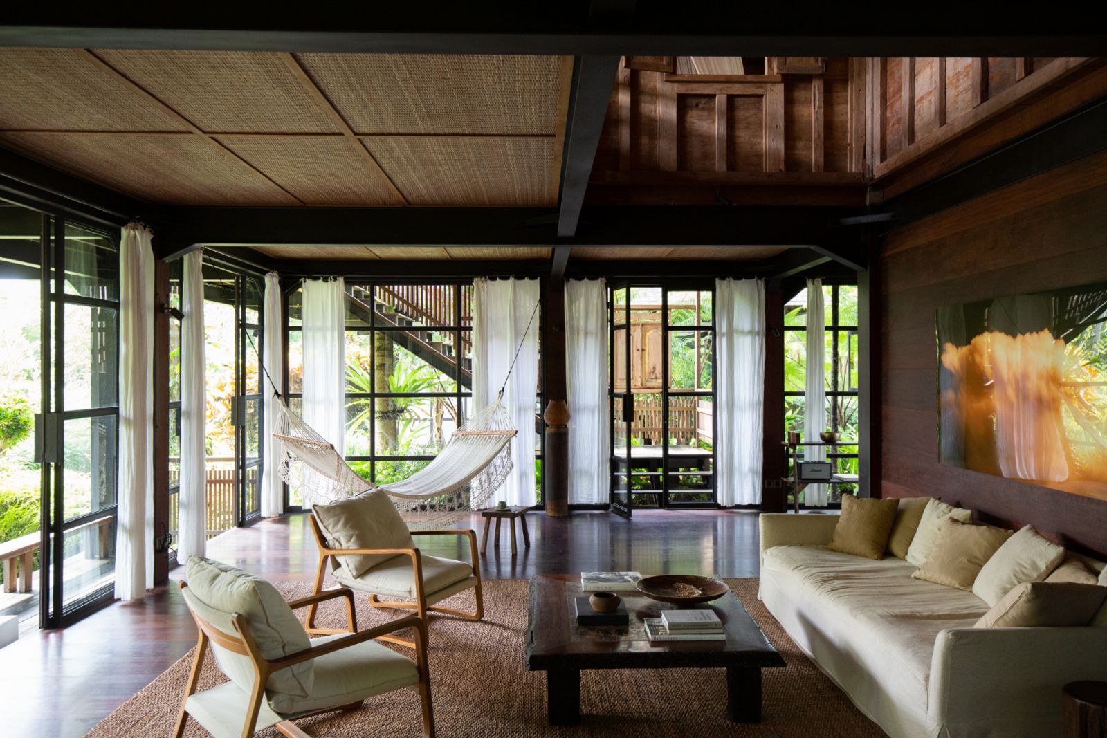 Sliding glass doors create a seamless connection with the surrounding nature (Photo: Rumah Hujan)