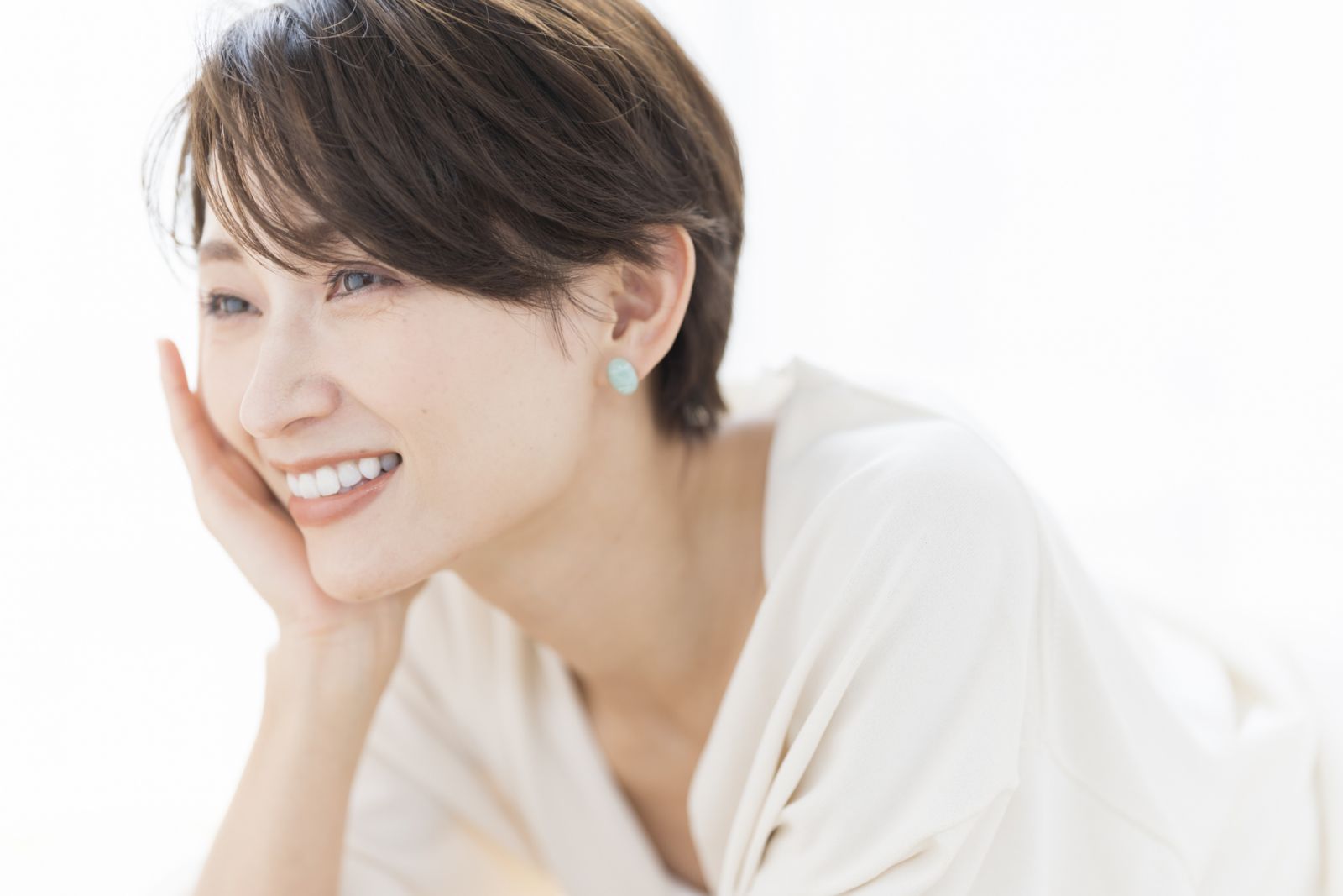 Profile of a middle-aged Japanese woman. She is lying down and posing with her elbows up.