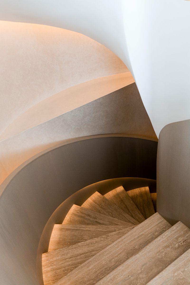 Carefully lit travertine steps lends a luxe feeling to the staircase