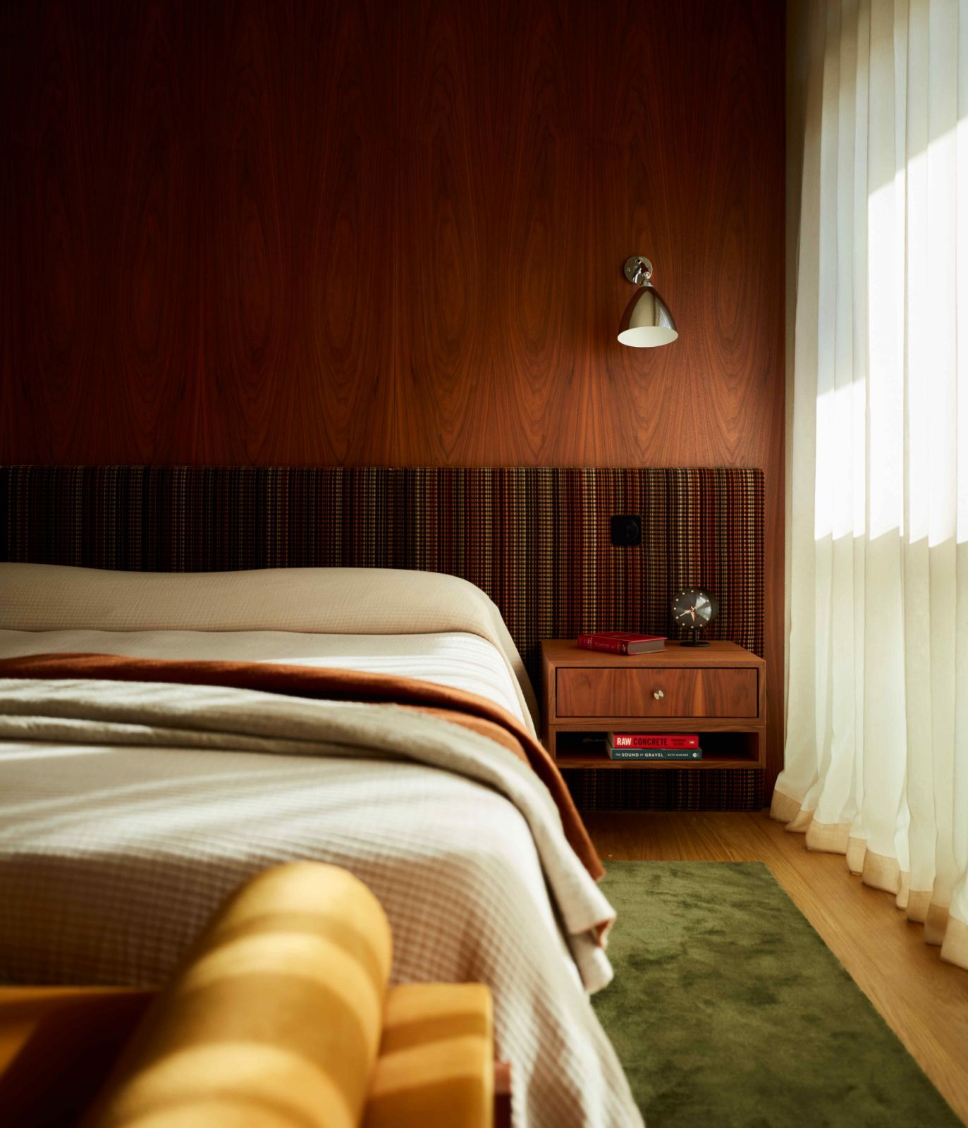 The bedroom feels warm and lived-in despite their modernity