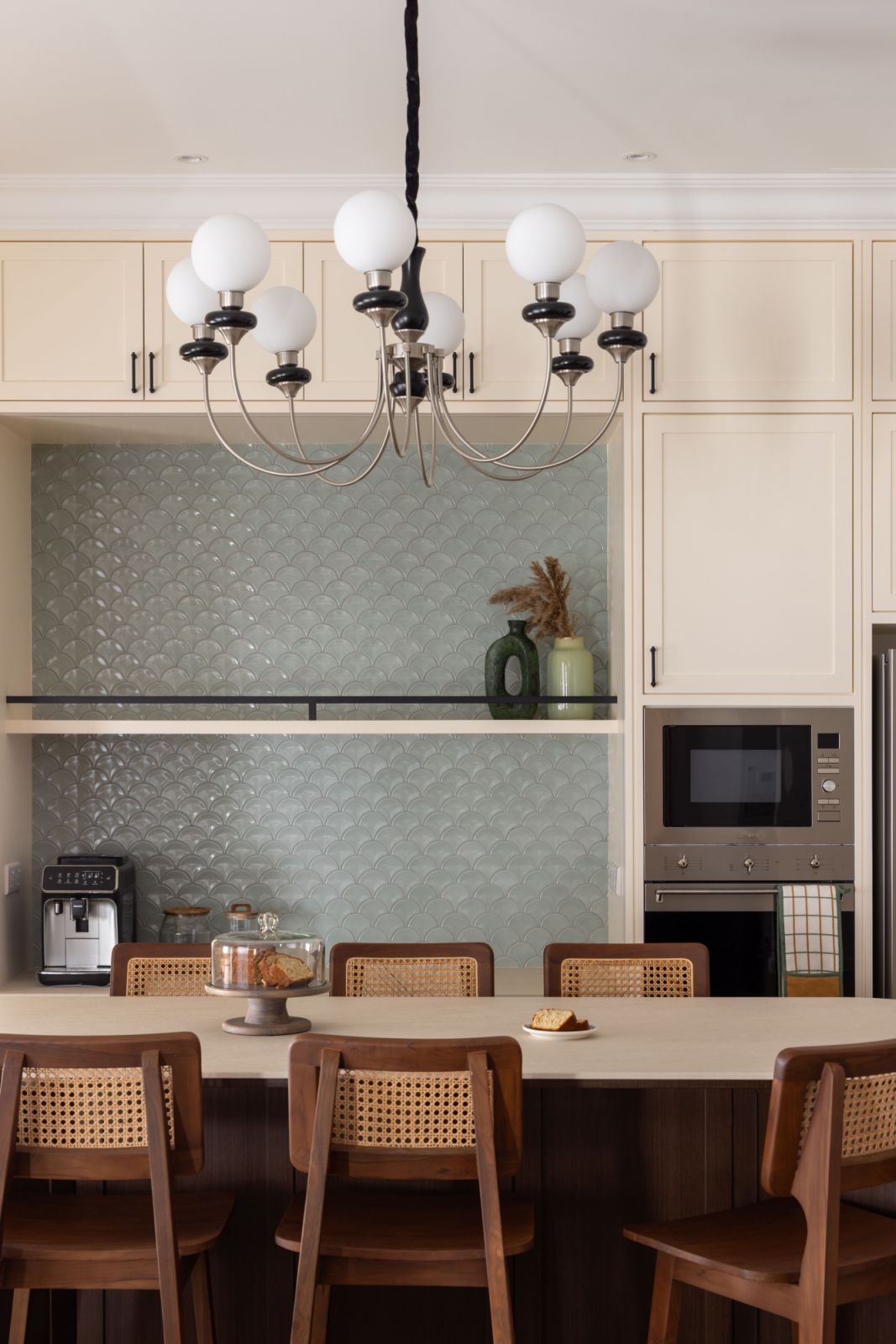 Handcrafted green fish scale mosaic tiles create a subtle yet striking backsplash