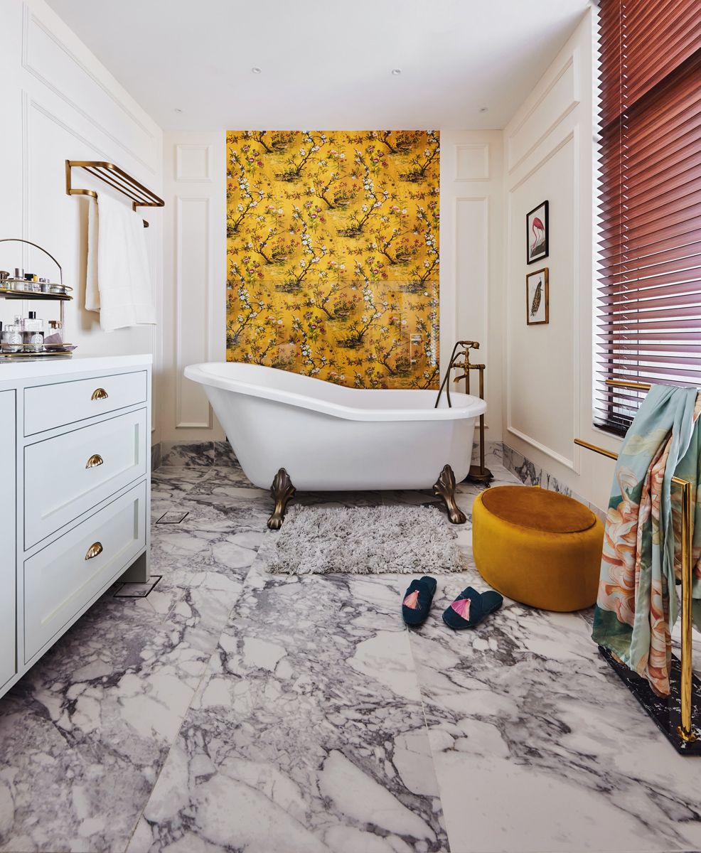 Wallpaper with an intricate print is utilised as a beautiful accent panel in this bathroom