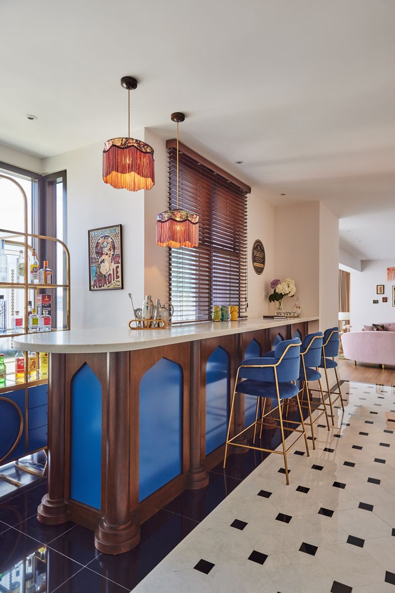 royal blue inlays and bar stools pop against the warm wood tones of this gothic-influenced bar counter