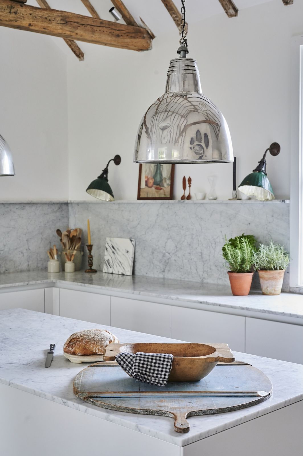 The kitchen, which contrasts exposed wooden beams with marble for a pleasant cooking and entertaining experience