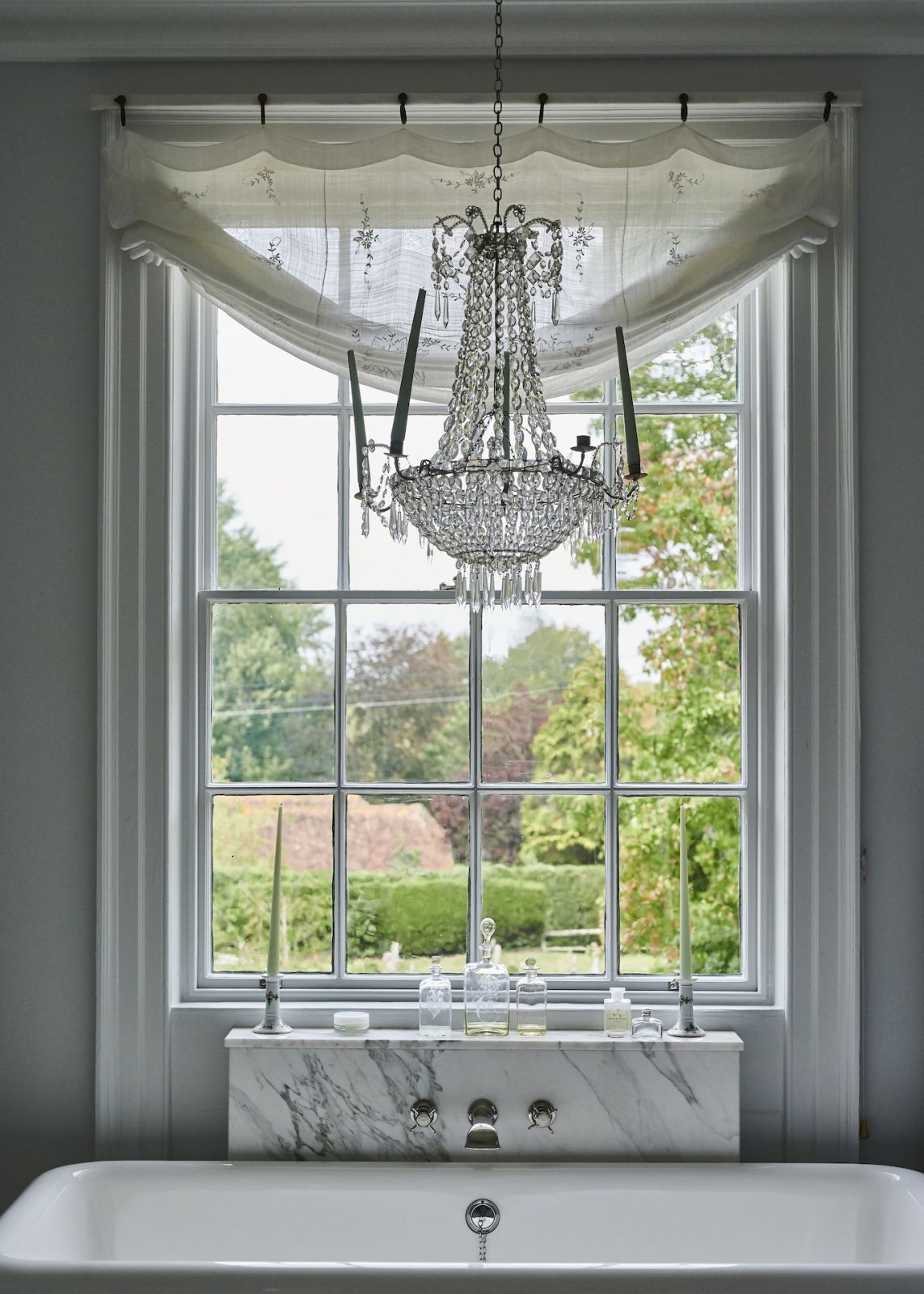 The chandelier hanging in the primary bathroom