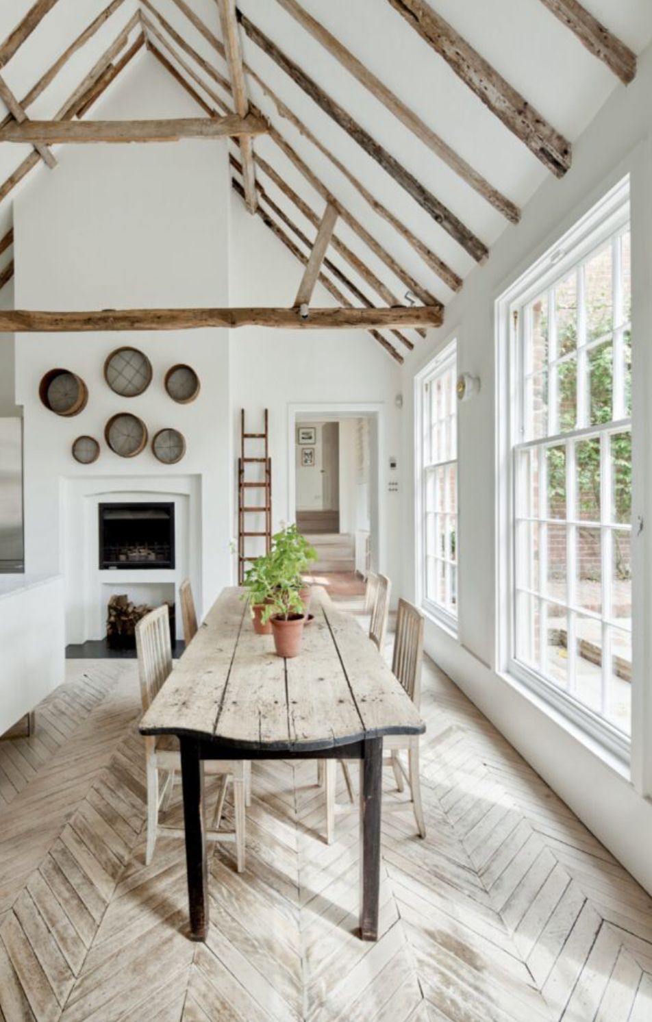 The kitchen table and herringbone-patterned floor complemented by the exposed wood beams on the ceiling