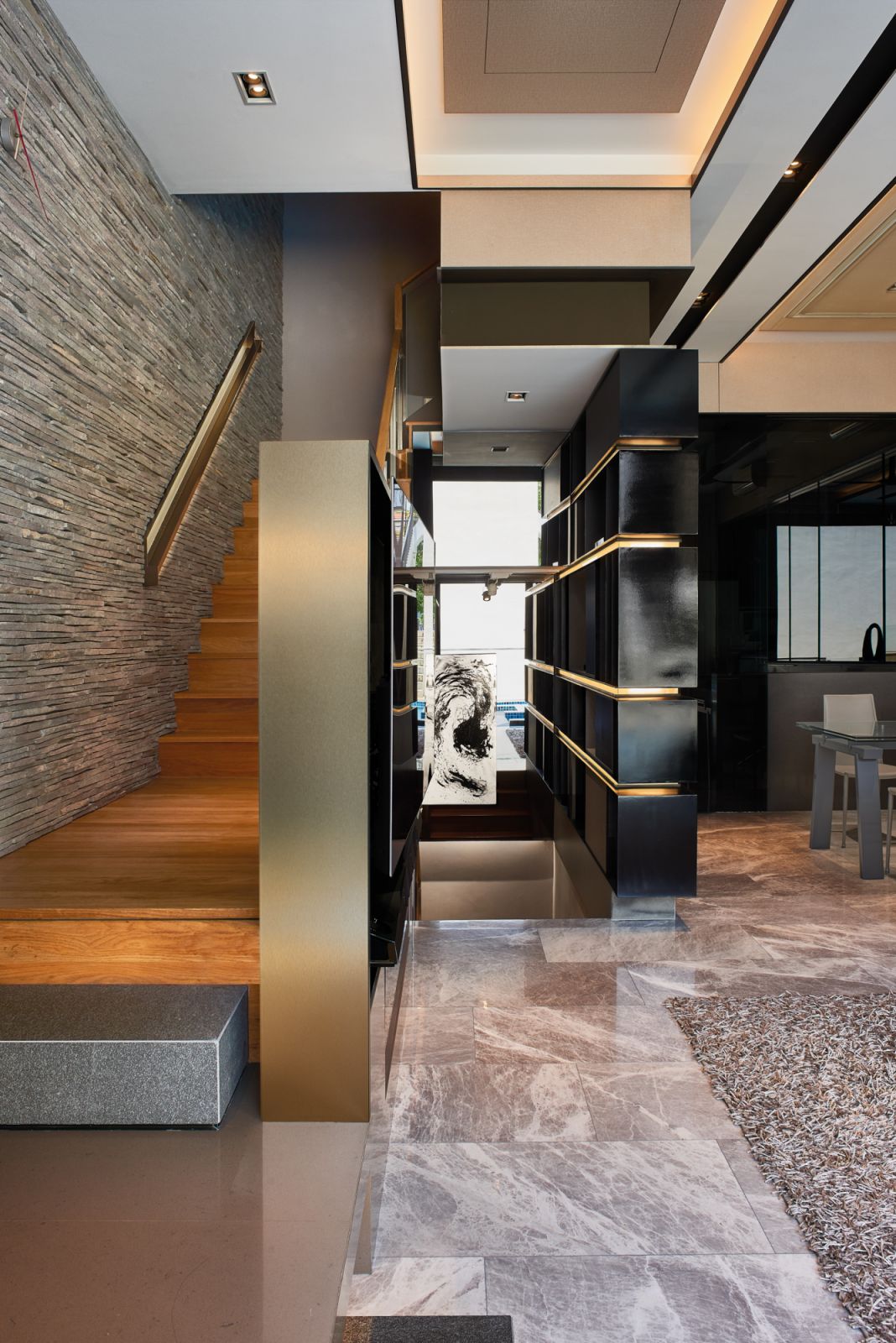A beautifully tactile stone wall adds depth to this stairwell