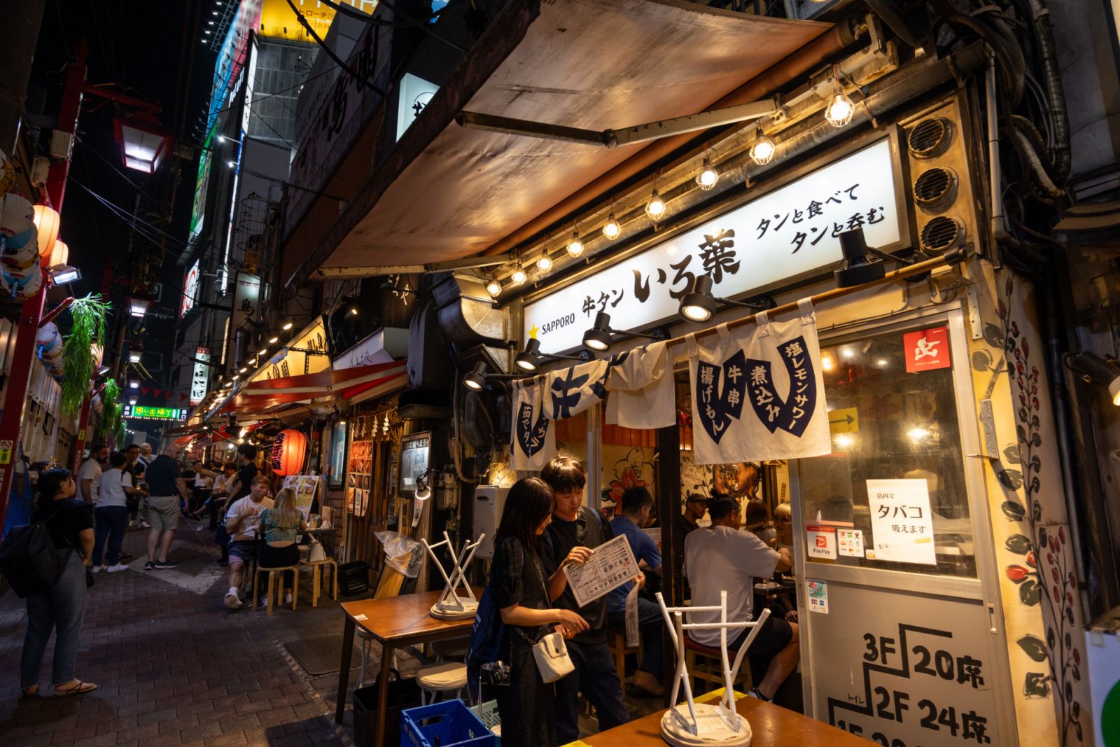 Tokyo, Japan - September 20, 2023 : People at the restaurants at night in Shinjuku, Tokyo, Japan.