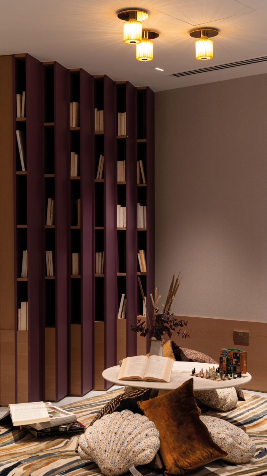 The upper-level family room features an eye-catching library finished in purple