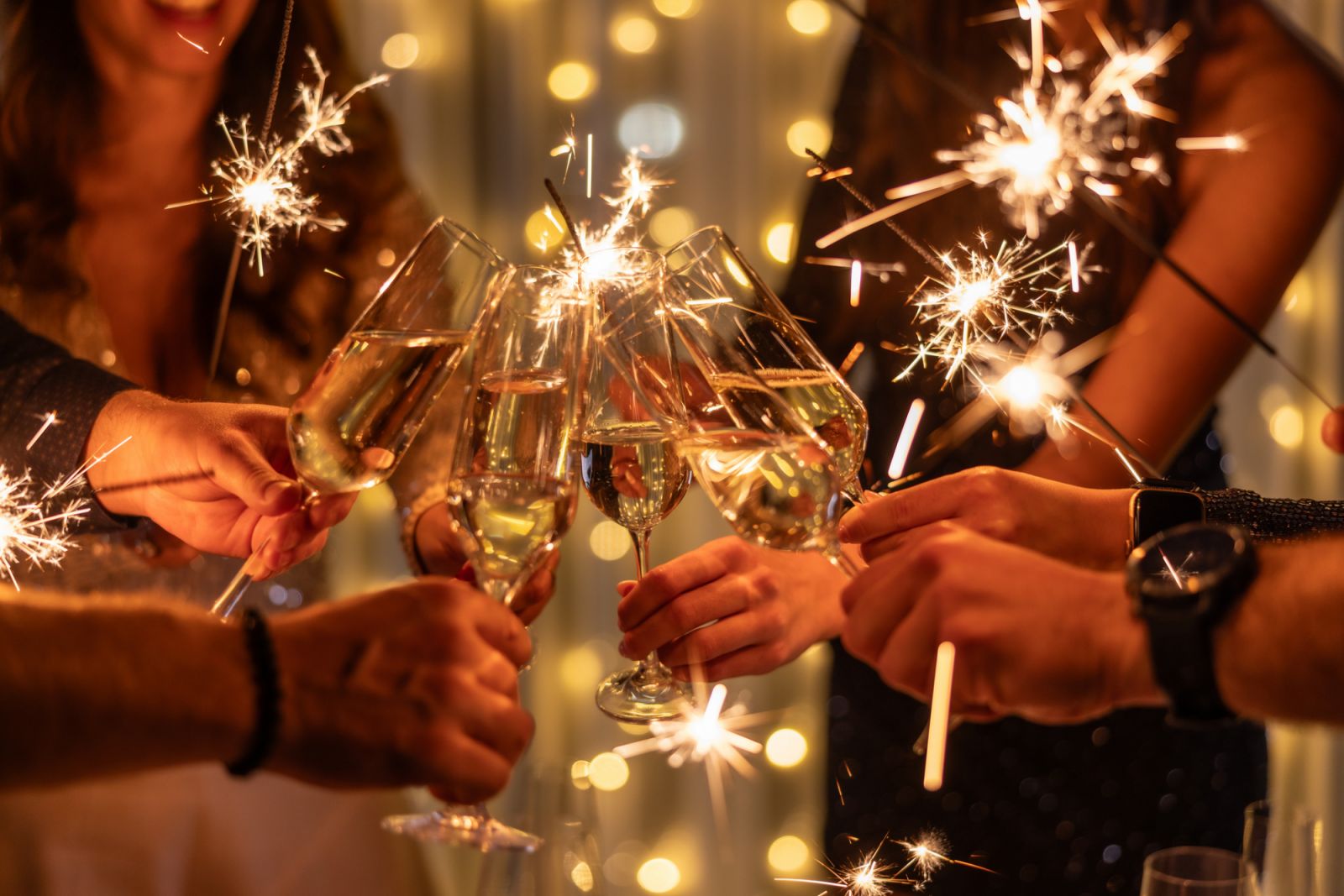 Sparkling sparklers in the hands. Playing firework to celebrate winter holidays with friends at the party. Magic New Year, Christmas.