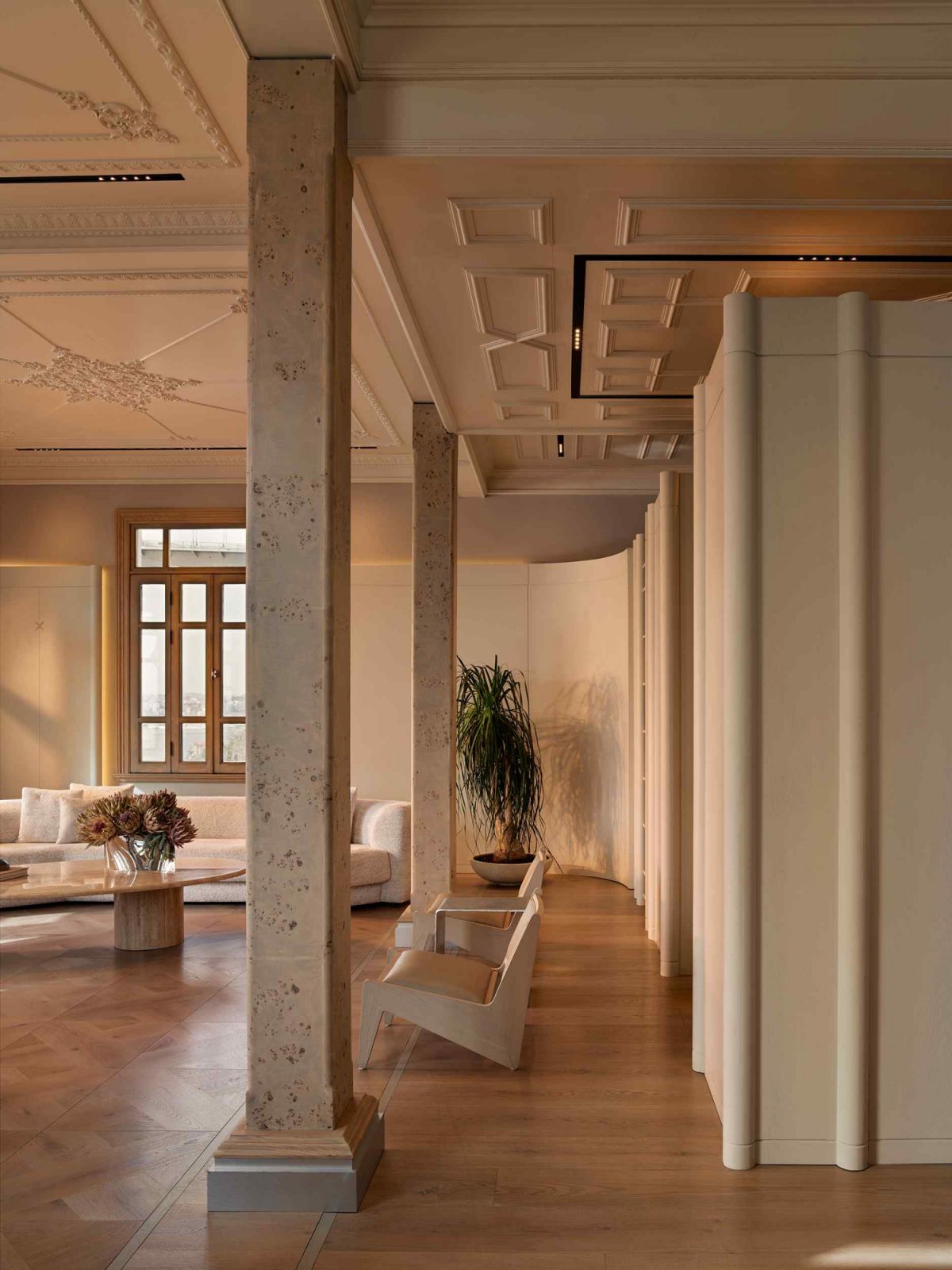 Travertine stone columns juxtapose the painted wood panels