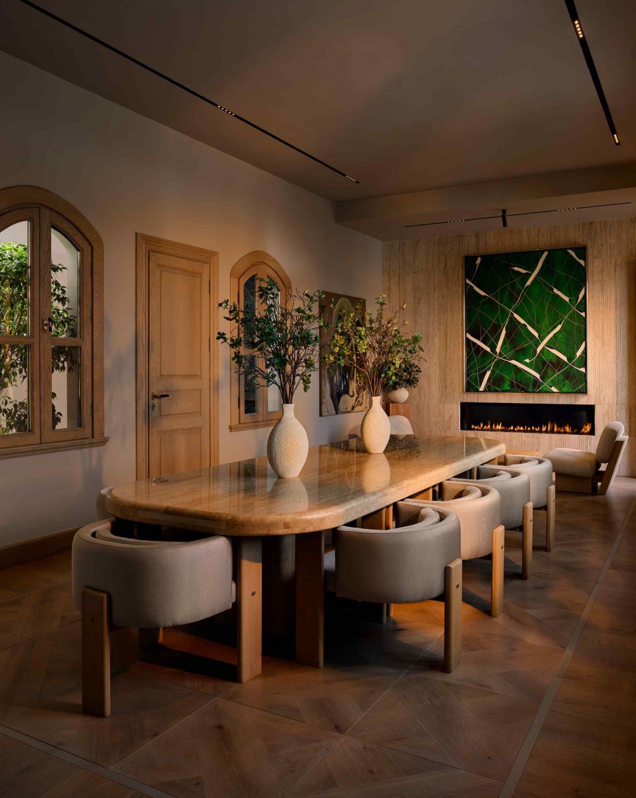 The dining room with arched windows and a polished stone dining table