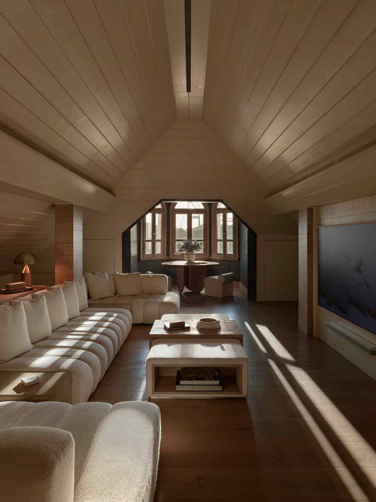 The living space in the attic with a pitched wooden ceiling