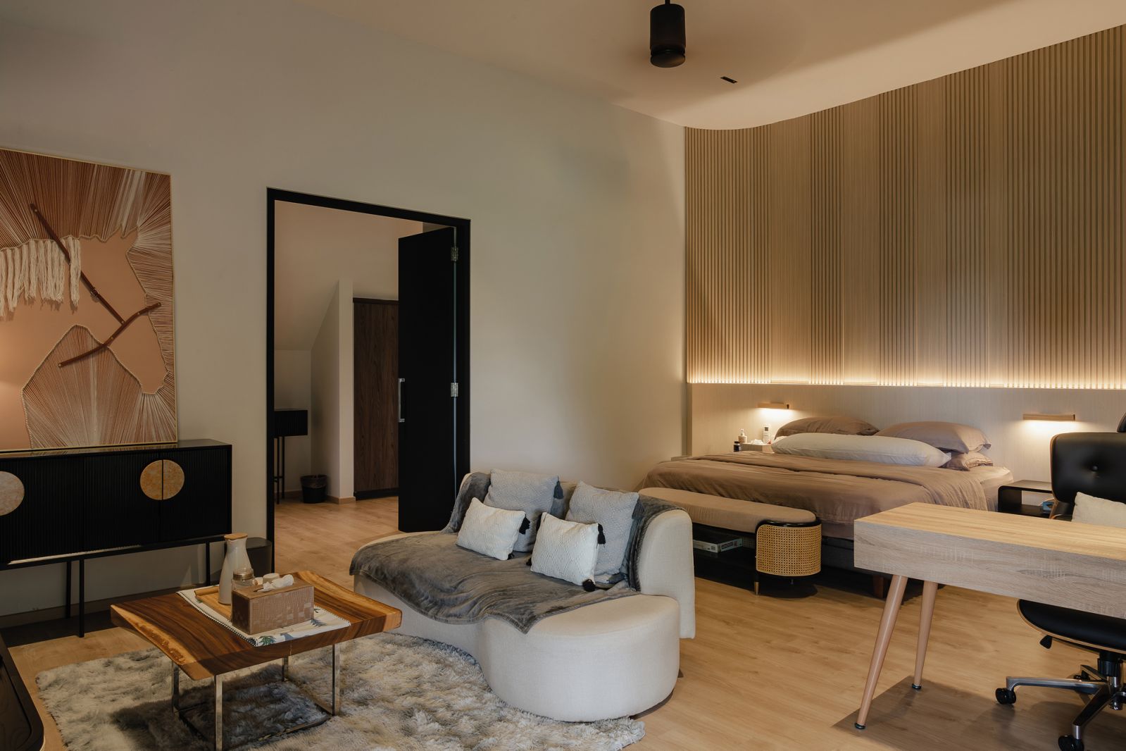 The open-plan master bedroom has a sitting area and a study