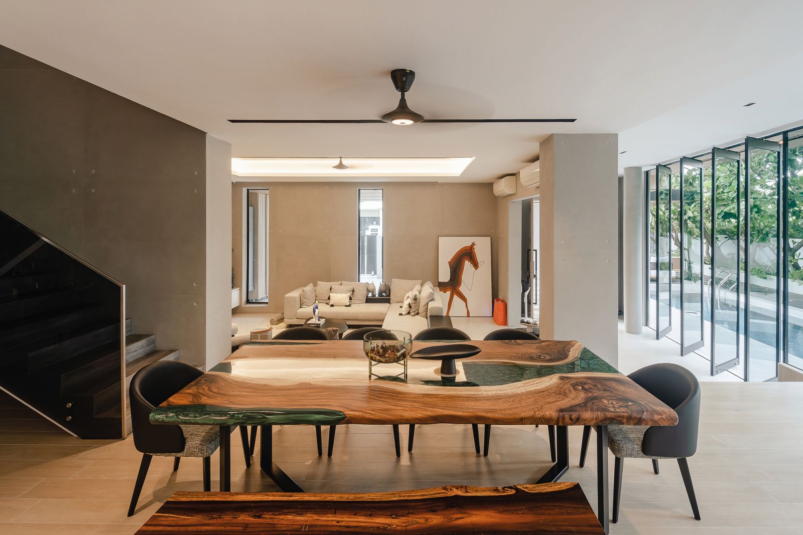 The dining table’s timber top features resin detailing that mimics flowing water in the home