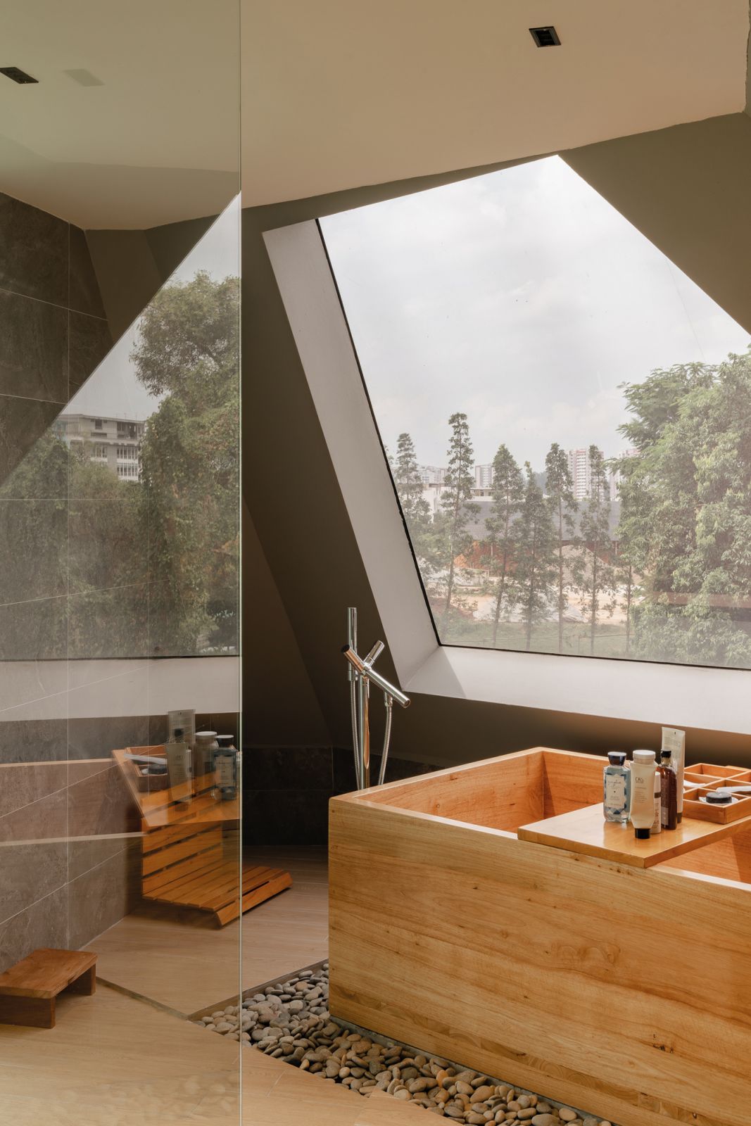 The zen bathroom features an onsen-like wooden bathtub and a picturesque view through the slanted window