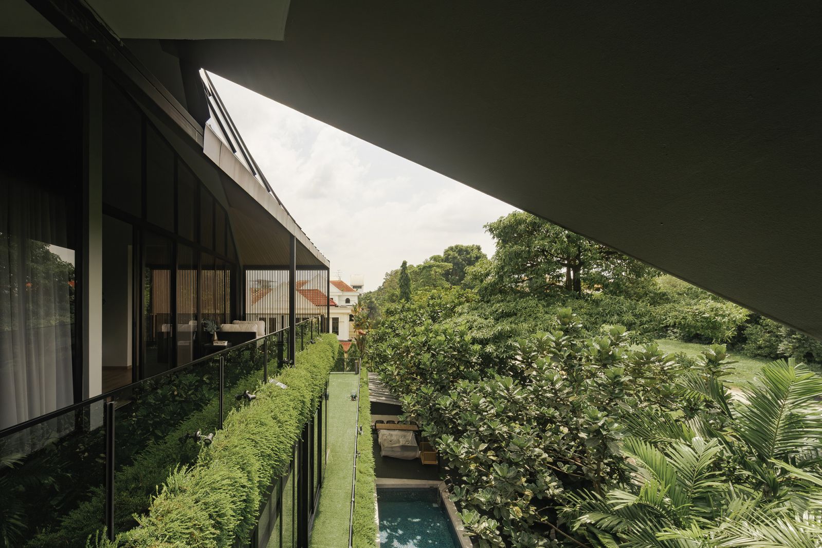 Finished with a mix of living plants and artificial turf, the home’s perimeter appears just like an extension of its lush green surroundings