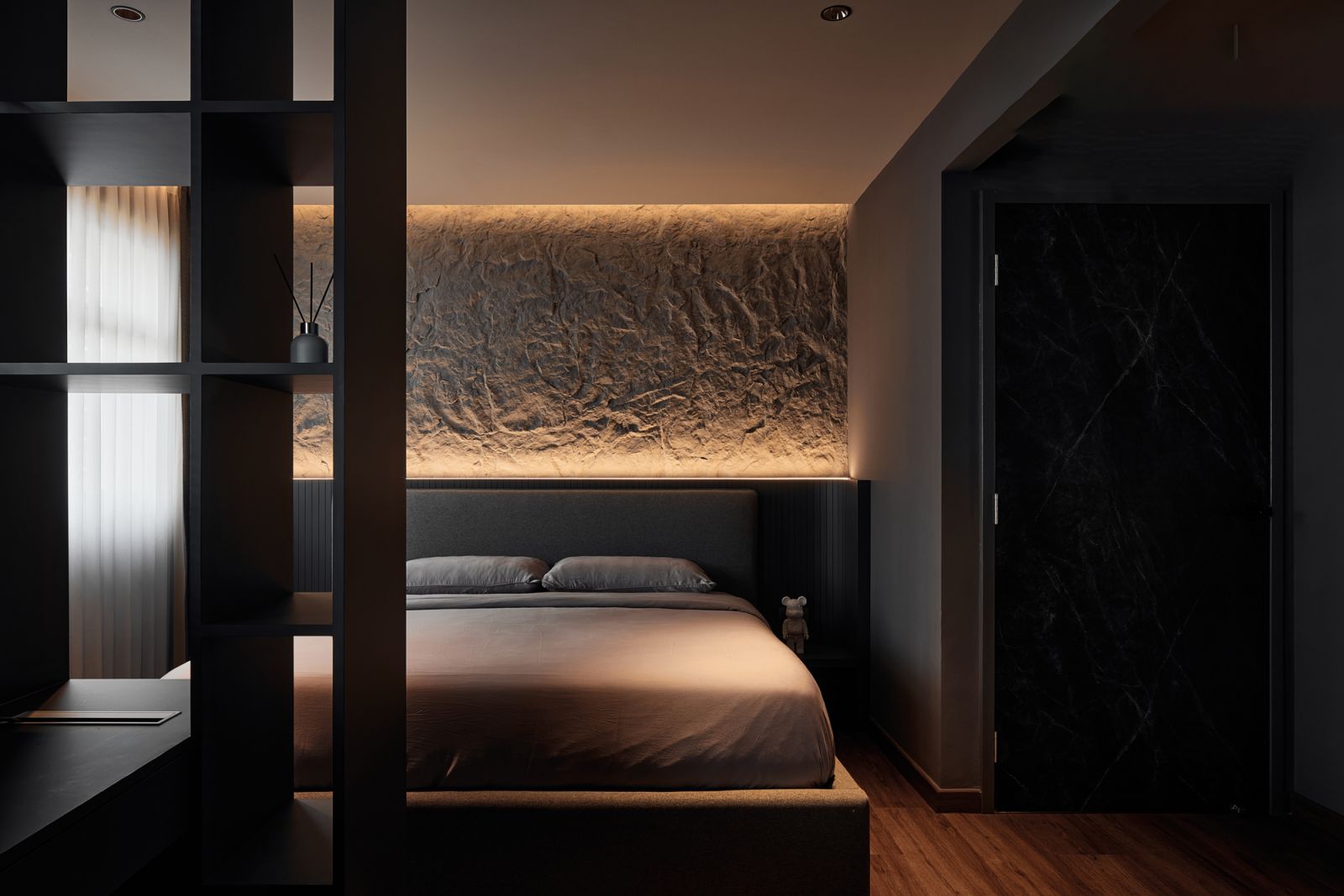 The hand-sculpted rock wall above the bed is the highlight of the master bedroom, with carefully positioned lights that emphasise its depth and dimensionality