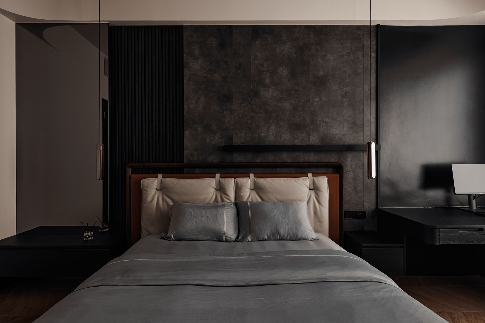 The textural grey material palette of the master bedroom lends a restful ambience