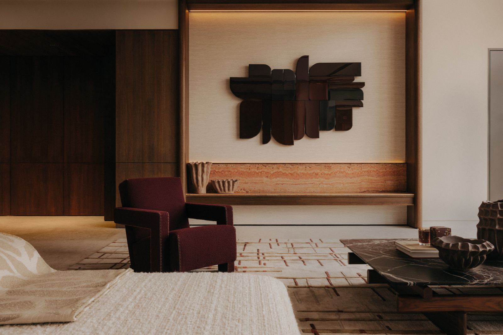 Gerrit Thomas Rietveld’s sculptural Utrecht armchair from Cassina pairs well with the timber artwork on the wall