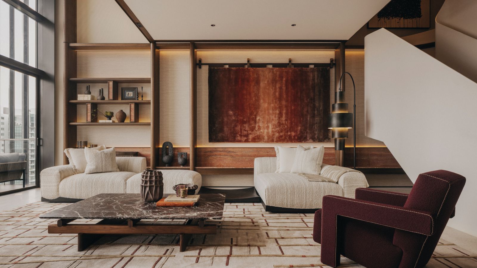 The home’s living room is enriched by shapely forms and deep burgundy accents