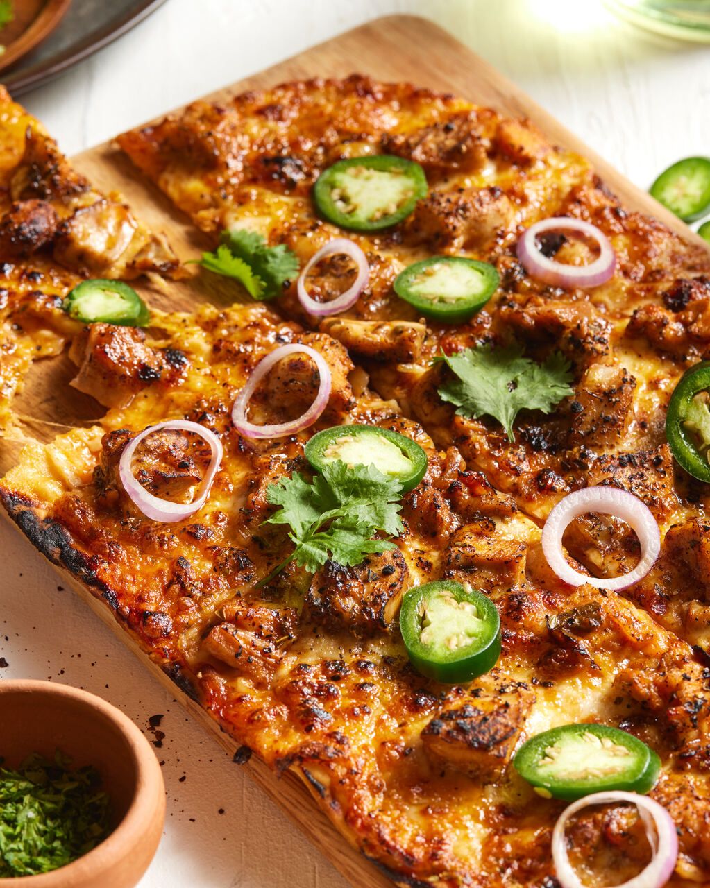 Barbecue Chicken Pizza: chunky barbecued chicken, onions, diced jalapeño, topped with red cheddar, mozzarella and fresh coriander