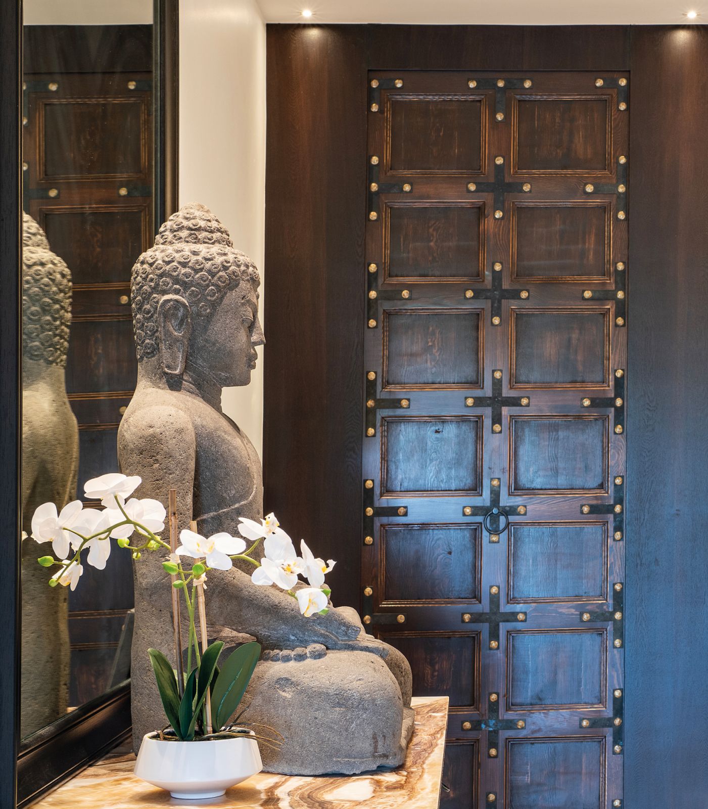Set on a bespoke base, this Buddha statue almost seems to watch over the entrance to the powder room