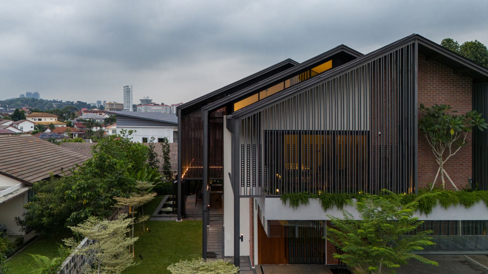 The side view reveals how the house’s stepped gable roof forms respond to the suburban context of Petaling Jaya