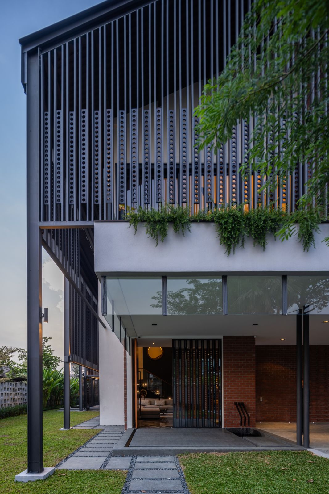 Vertical timber screens with punched holes, inspired by traditional kampung house ventilation elements