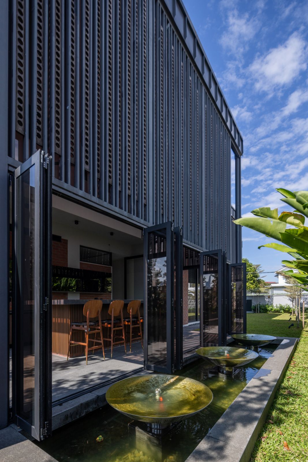 The bar's exterior view reveals how the Chengal timber screens work with the folding doors and water features