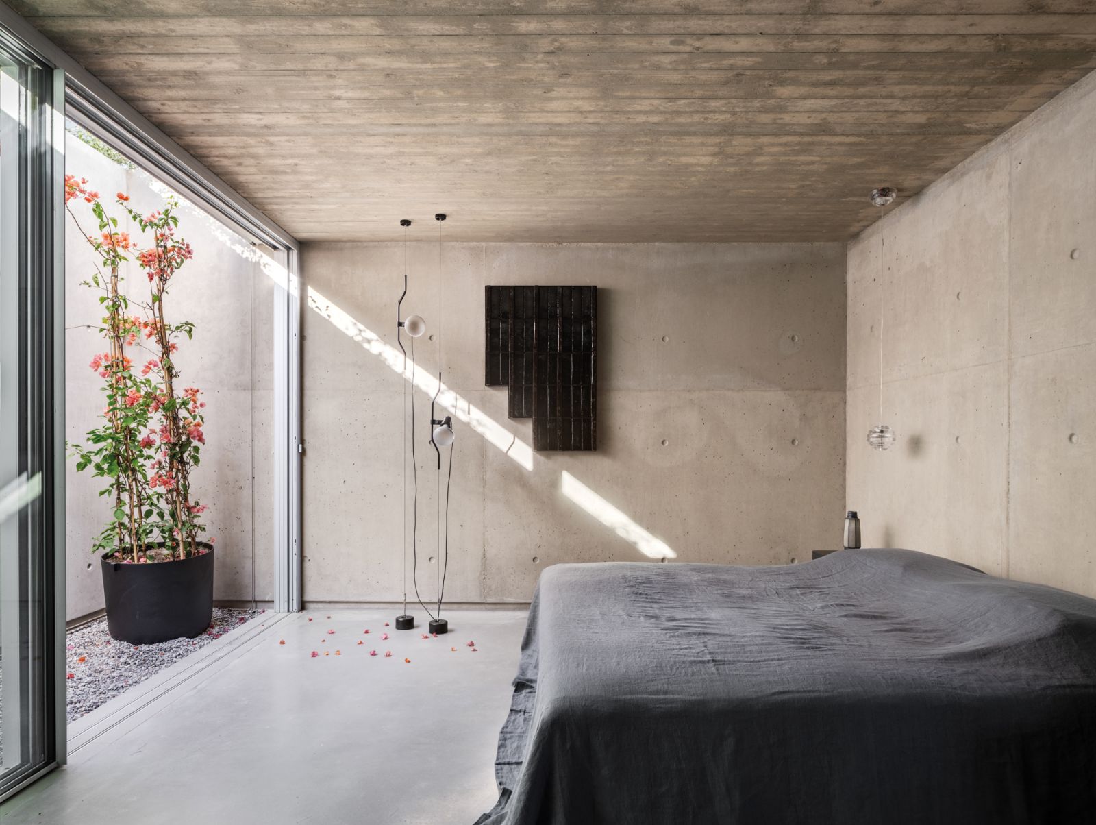 A poetic corner of a bedroom with a clever architectural incision that brings natural light in