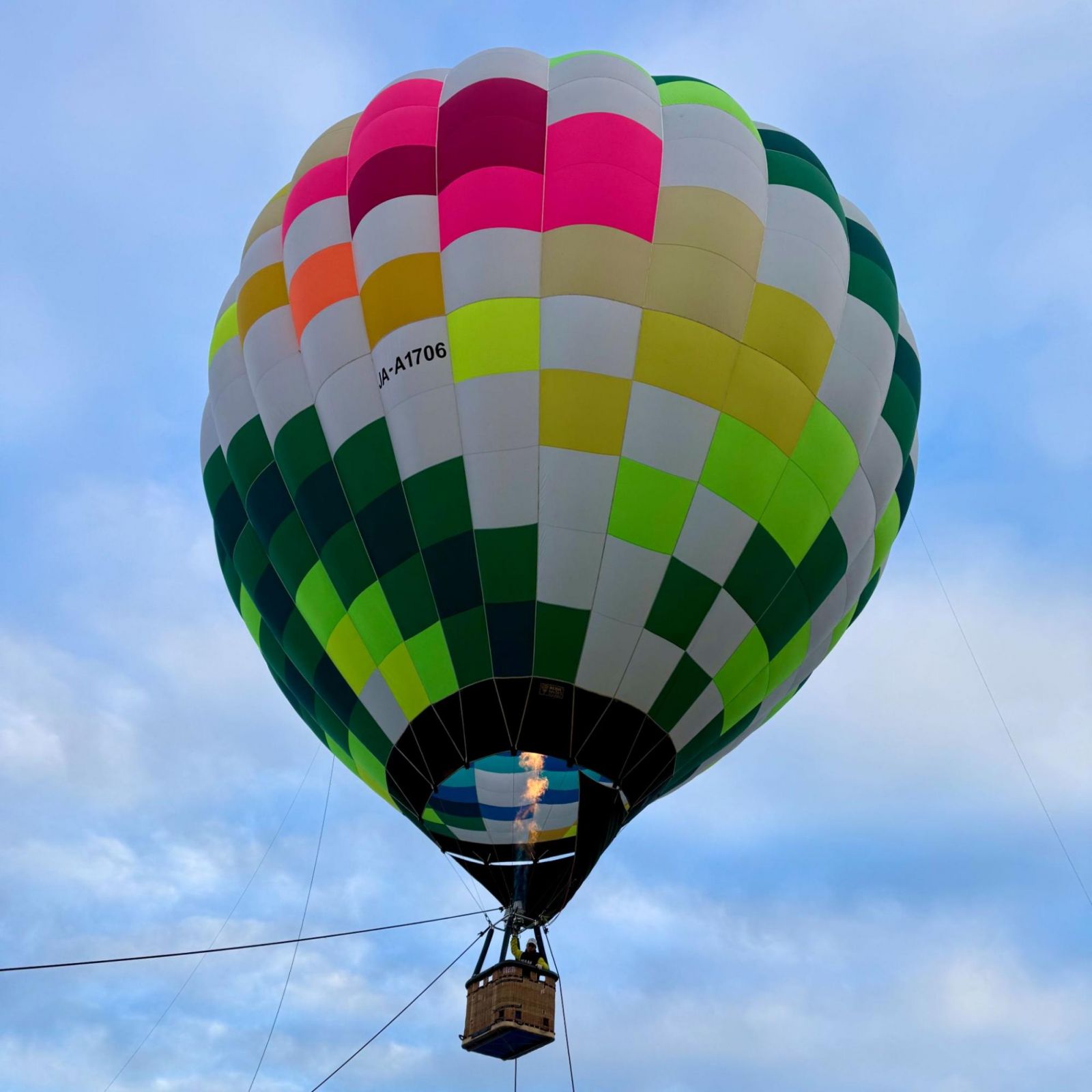 A ground-pegged hot air balloon overlooks Yonezawa City and Iide mountain range