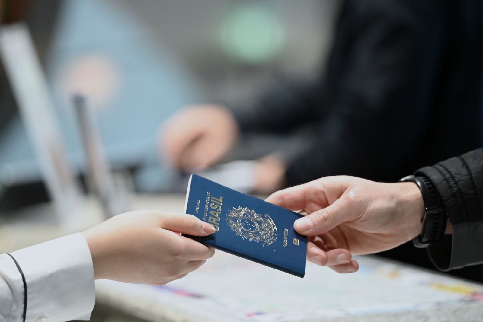 26 September 2024, Berlin: A hotel employee gives a guest his passport back at the reception desk when he checks in. Photo: Katharina Kausche/dpa (Photo by Katharina Kausche/picture alliance via Getty Images)