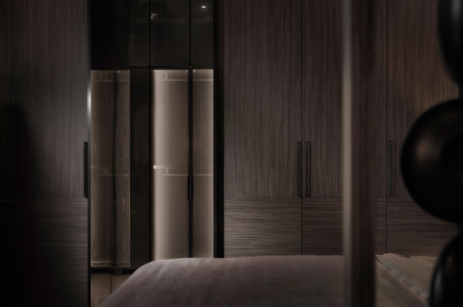 Tone-on-tone finishes and softly lit fluted glass create a subtle yet rich spatial experience