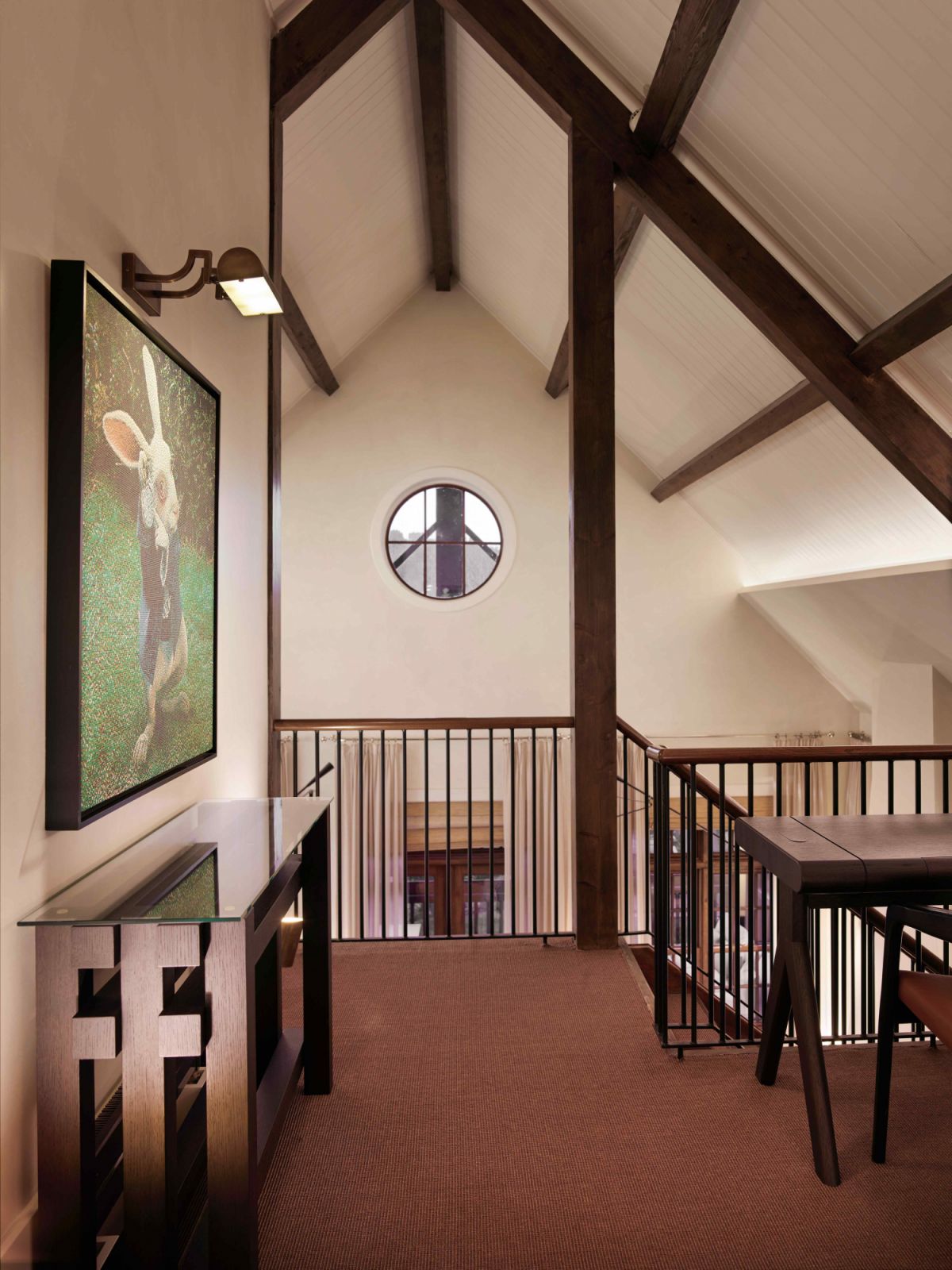 The pitched roof and wood beams culminate at the upper floor