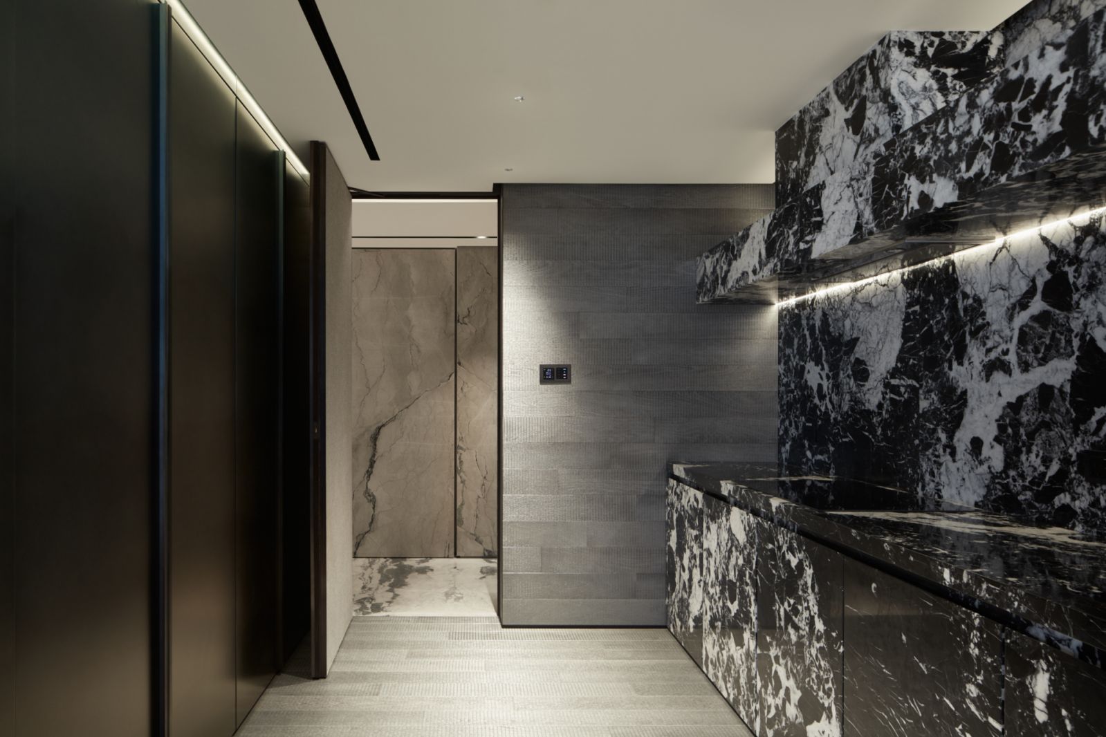 The nearby kitchen with black marble all over the counters, backsplash and cabinets