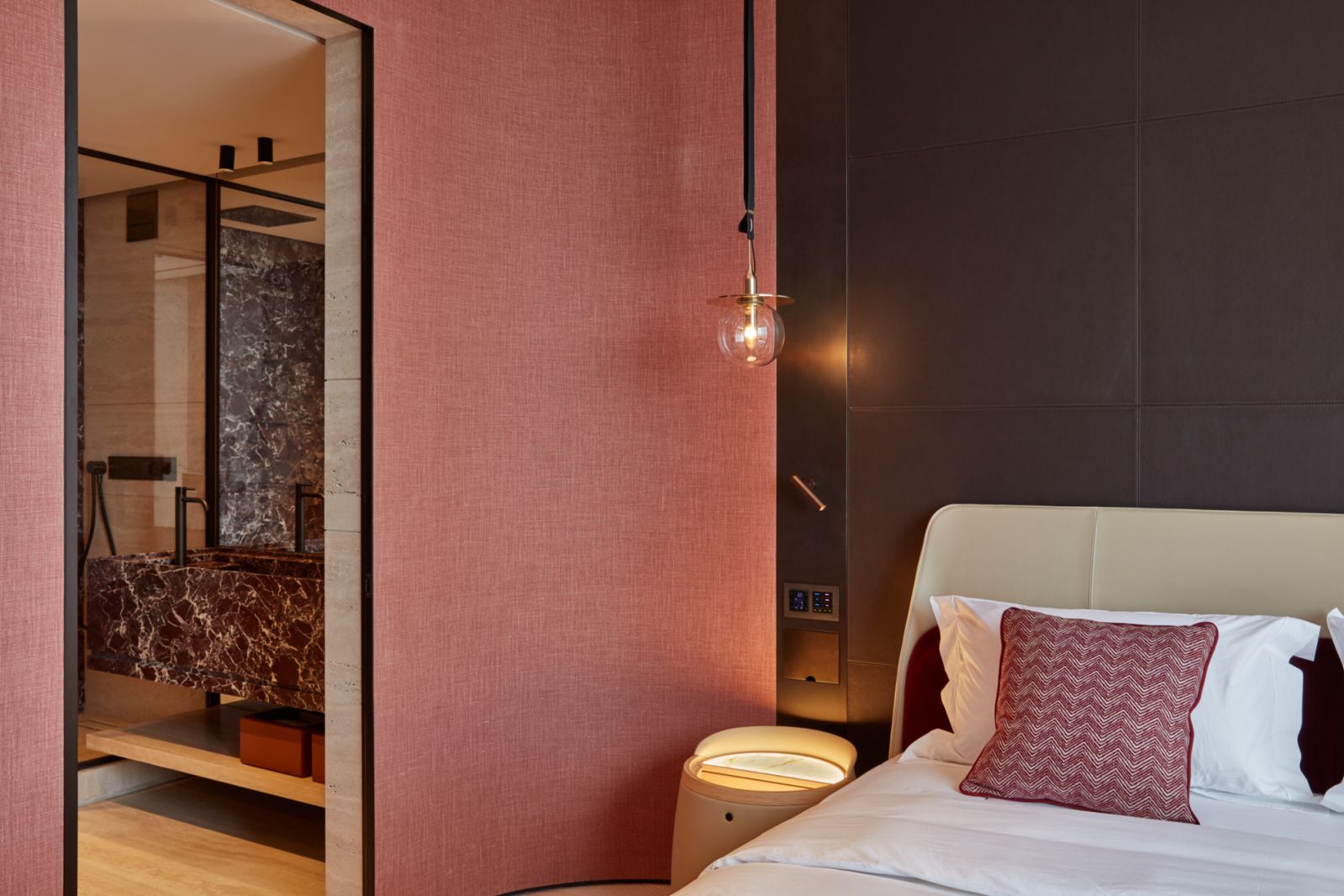 Textured wallpaper and stitched leather adding unexpected dimension to the bedroom