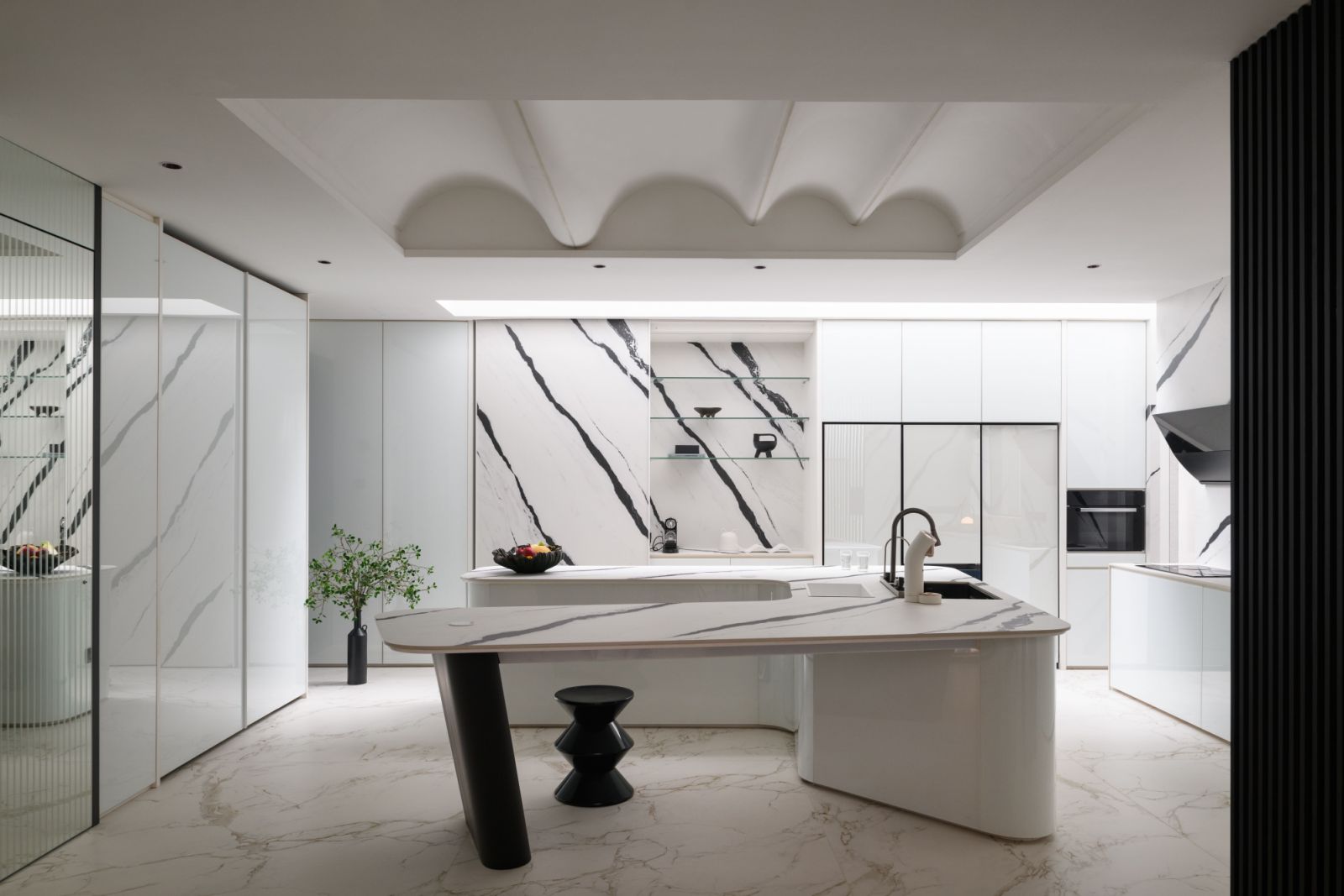 Bold black marble veining makes a dramatic statement in the kitchen, where an undulating ceiling design adds a playful touch to the modern space