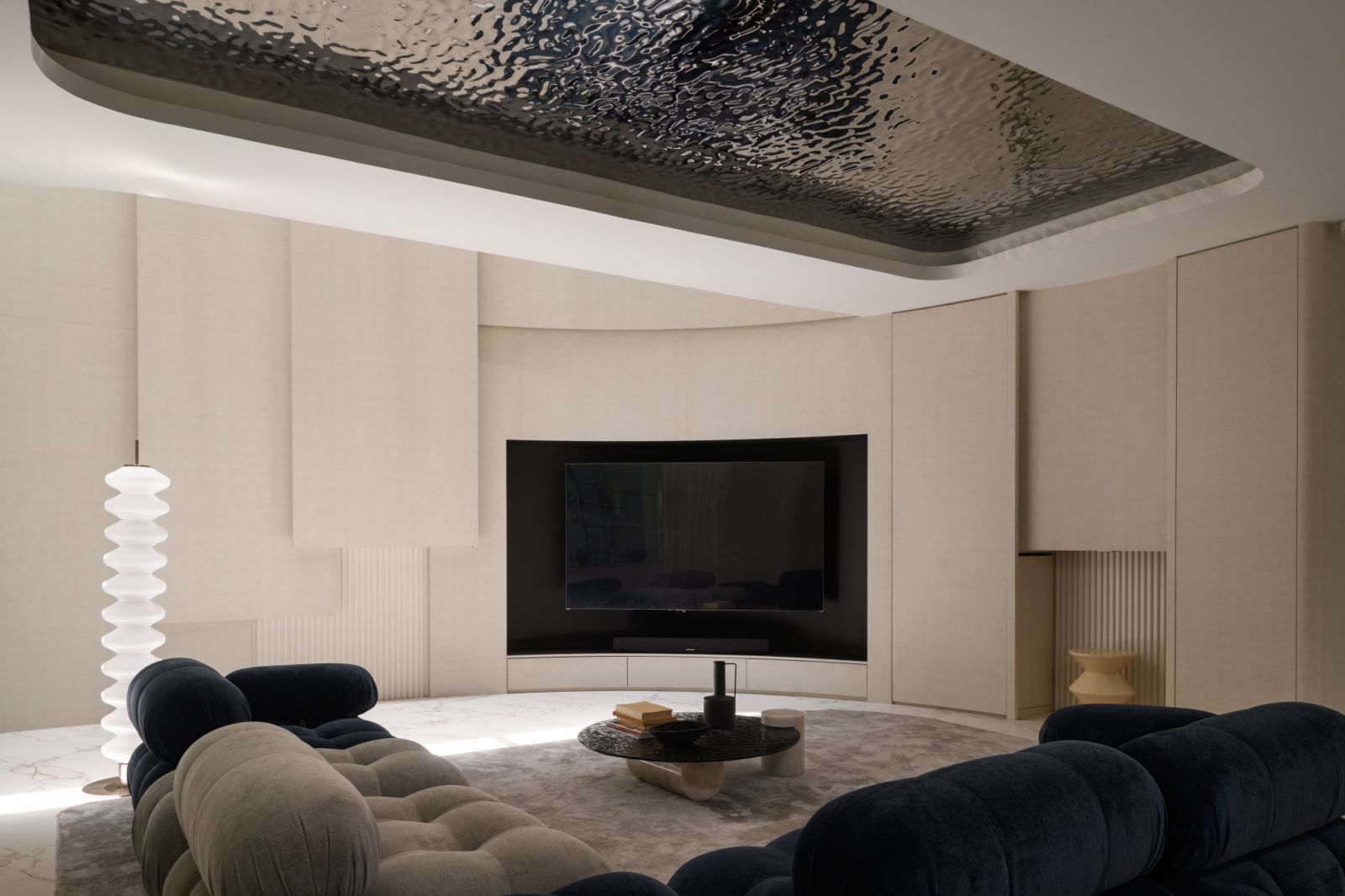 Low-slung sofas in plush upholstery create an inviting conversation pit beneath the sweeping curved ceiling