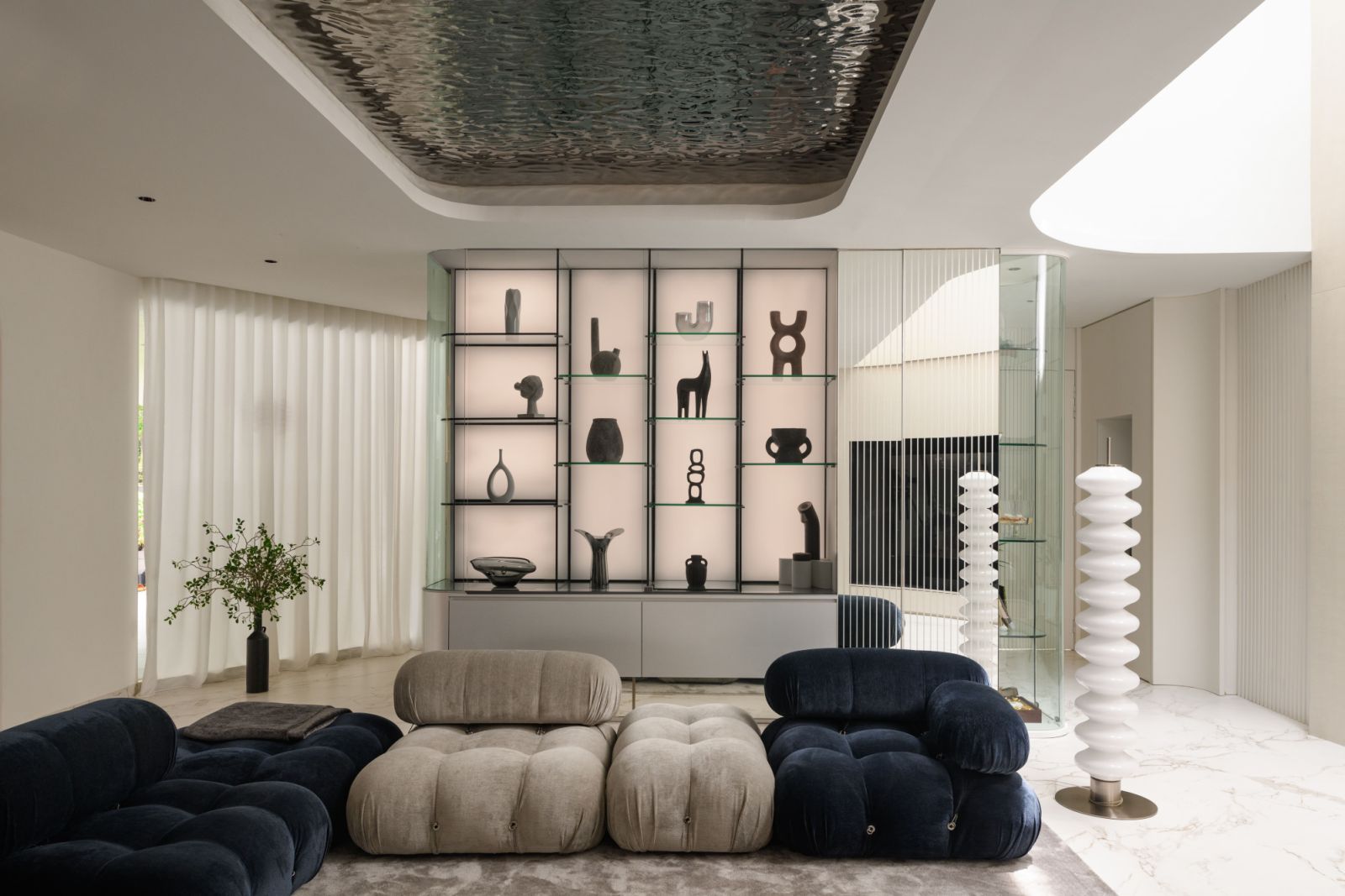 Low-slung sofas in plush upholstery create an inviting conversation pit beneath the sweeping curved ceiling