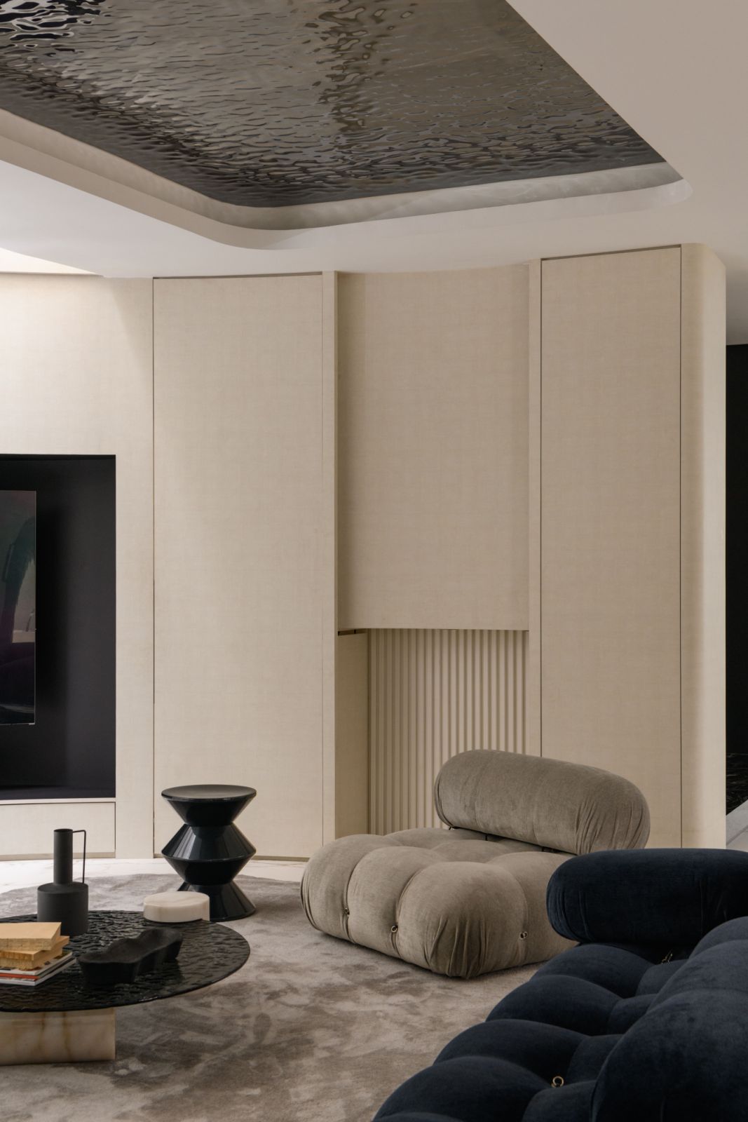 Low-slung sofas in plush upholstery create an inviting conversation pit beneath the sweeping curved ceiling
