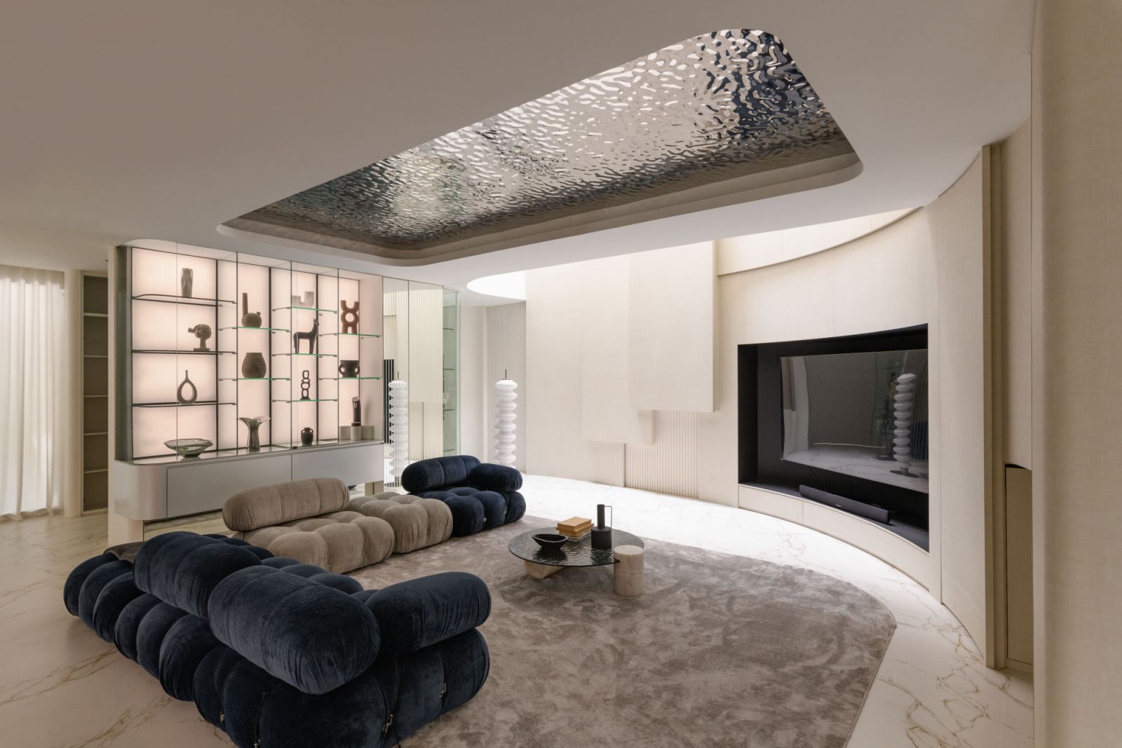 Low-slung sofas in plush upholstery create an inviting conversation pit beneath the sweeping curved ceiling